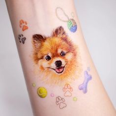 a small dog's face on the wrist with paw prints and other things around it