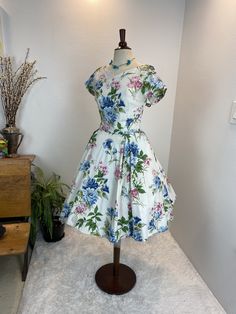 1950s dress / 50s dress / 1950s floral dress This 1950s dress is perfect for a warm day. She is a 1950s cotton floral fit and flare with a center back metal zipper. She is a creamy white with a floral pattern in pink, blue, green and beige. She has the typical nipped waist and super full skirt. She looks beautiful with a petty coat under or without! Measurements provided are flat and have been doubled. Bust 38" Waist 28" Hips free Length 39" ❤️ Condition: Excellent vintage condition. Flaw:  none found. This item has been cleaned and is ready to wear. $168 includes domestic shipping and insurance. International shipping is $30. Please let me know if you have questions, would like more measurements, or photos. I am here to help. 💜Megan Cotton Floral Print Vintage Dress For Garden Party, Cotton Vintage Dress With Floral Print For Garden Party, 1950s Style Floral Print A-line Dress, 1950s Floral Print A-line Dresses, Short Sleeve Floral Print 1950s Dress, 1950s Style A-line Floral Print Dress, 1950s Style Floral Print Short Sleeve Dresses, 1950s Style Floral Print Vintage Dress, 1950s Style Vintage Dress For Garden Party