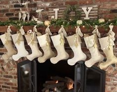 christmas stockings hanging from the mantel over an open fire in front of a brick fireplace