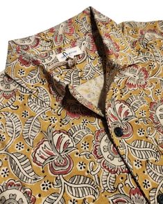 a shirt that is yellow and red with paisley print on the front, it has a button down collar