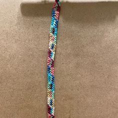 a multicolored beaded necklace hanging on a wall