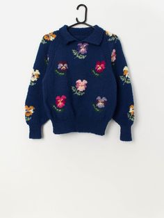 Vintage handknitted pansy floral collared jumper in blue. This beautiful blue 90s jumper features a pansy floral pattern throughout, long sleeves and a collared neckline. Made from a heavyweight wool. Our recommended size: Small Label says: No size label Condition: Very good Material: No care label, confident it is wool Measurements in inches: Pit to pit: 18 Front length: 21.5 Back length: 21 Sleeve length: 24 Hem unstretched: 12.5 Hem stretched: 16 We recommend that you compare our measurements Blue Collared Polo Sweater For Winter, Collared Jumper, 90s Jumper, Pullover Sweater Women, Size Label, Care Label, Pansies, Women Pullover, Beautiful Blue