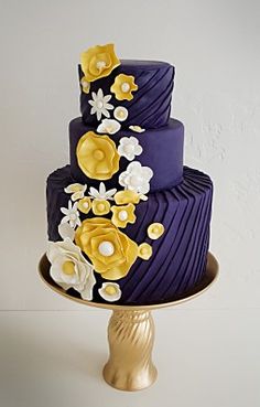 a purple and gold wedding cake with flowers on the top is featured in an instagram