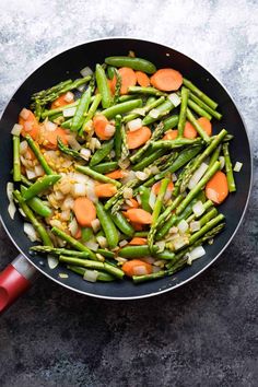 asparagus, carrots and onions in a skillet