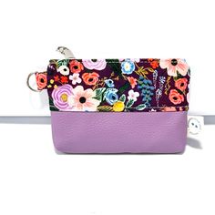 a purple purse with flowers on it and a keychain hanging from the side