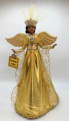 a gold angel figurine with a tag on it's chest and wings