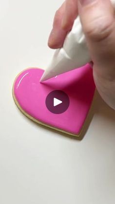 someone is cutting out a heart shaped cookie