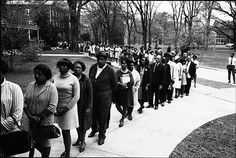 a long line of people walking down a sidewalk