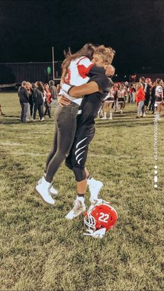 two girls hugging each other on the field