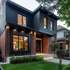 a modern house with black siding and windows