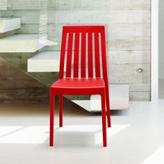 a red chair sitting in front of a stair case