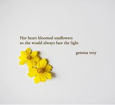 two yellow flowers sitting next to each other on a white surface with the words, her heart bloomed sunflowers so she would always face the light