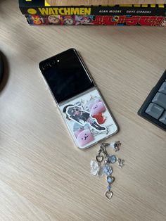 a cell phone sitting on top of a wooden table next to a keyboard and mouse