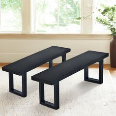 two black benches sitting on top of a white rug