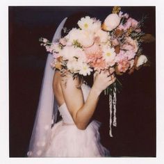 a woman in a wedding dress holding a bridal bouquet