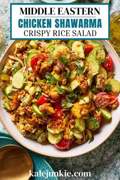 a white bowl filled with chicken, cucumber and tomato salad on top of a table