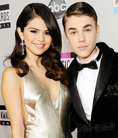 a young man and woman standing next to each other in formal wear at an event