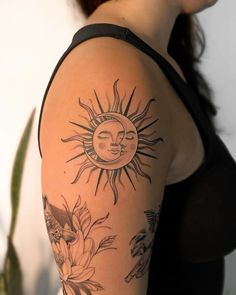 a woman's arm with sun and flowers on it