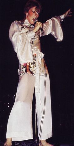 the man is dressed in all white on stage