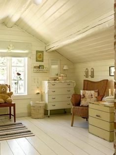 an attic bedroom with white walls and wooden flooring, teddy bears on the dressers