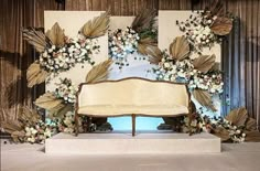 a couch sitting in front of a mirror with flowers on it