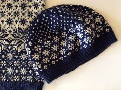 a blue and white knitted hat next to a sweater