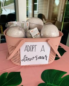 a pink basket filled with lots of balls on top of a table