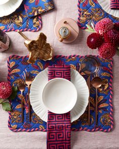 a place setting with pink and blue table cloth