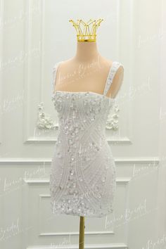 a white dress on a mannequin with a crown on it's head