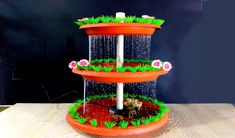 three tiered water fountain with flowers and grass