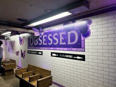 a man standing in front of a sign that says obesed on it's wall