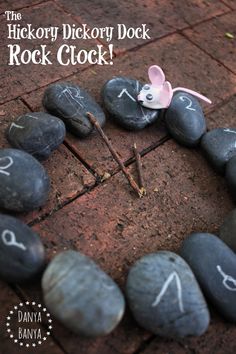 rocks arranged in the shape of a circle with numbers written on them and a pink bow