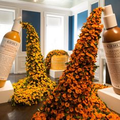 an assortment of beauty products on display in a room with blue walls and yellow flowers