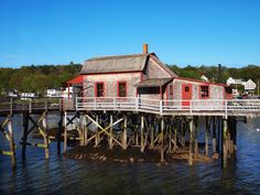 an old wooden house sitting on top of a pier