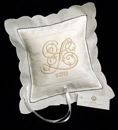 a white pillow with an embroidered monogram on it