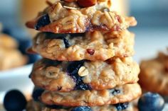 a stack of oatmeal cookies with blueberries and almonds on top