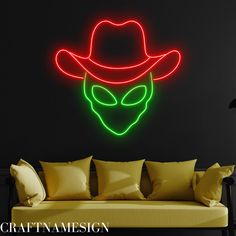 an alien man wearing a hat and glowing neon lights on the wall above a couch