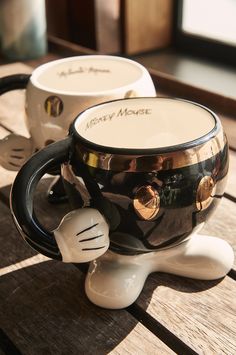 two coffee mugs sitting on top of a wooden table