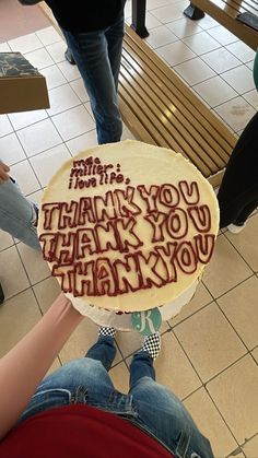 a person holding a cake with writing on it