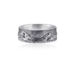 a silver ring with mountains in the middle and snow on it's sides, against a white background