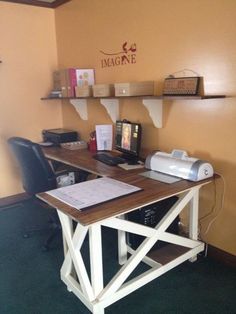 a desk with a computer and printer on it in a room that has yellow walls