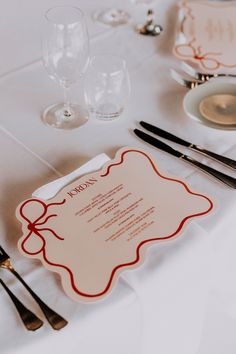 the table is set with silverware and place settings