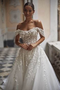 a woman in a wedding dress posing for the camera with her hands on her hips