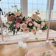 the table is set with pink flowers and candles for an elegant wedding reception or bridal party