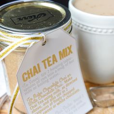 a cup of coffee next to a jar with a label on it that says chai tea mix