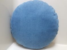 a blue round pillow sitting on top of a white table