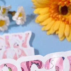 a close up of a happy birthday card with flowers in the background