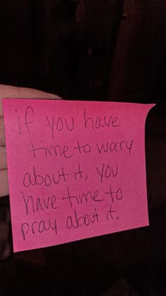 a hand holding a pink piece of paper with writing on it that says if you have time to worry about it, you have time to pray about it