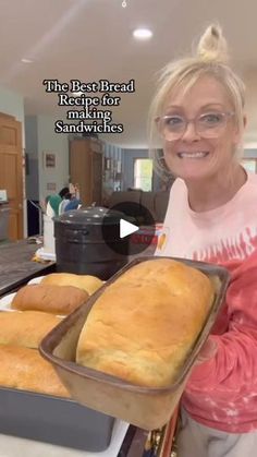 a woman holding a loaf of bread on top of a pan