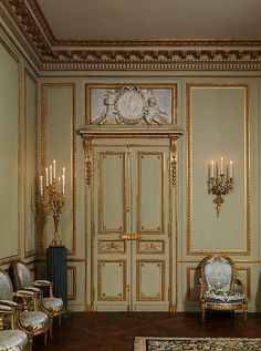 an ornately decorated room with gold trimmings and fancy chairs in front of the door